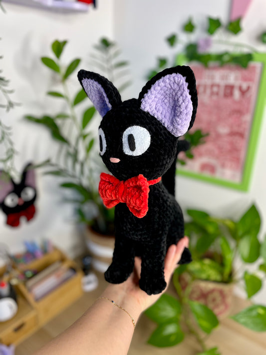 Grand chat noir avec nœud rouge