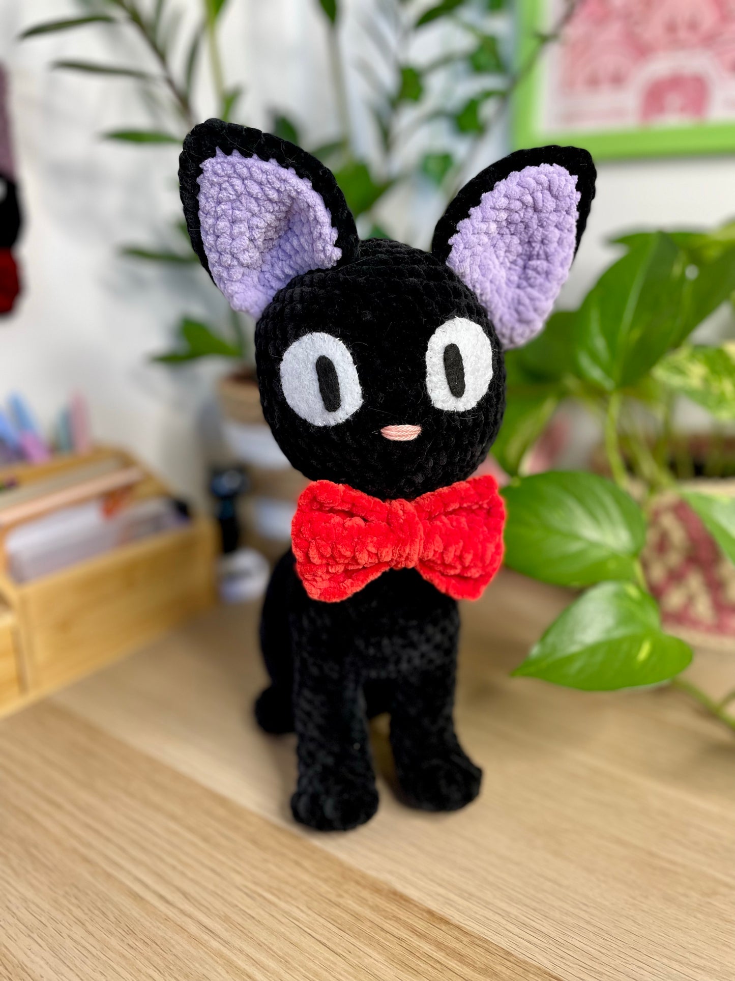 Grand chat noir avec nœud rouge