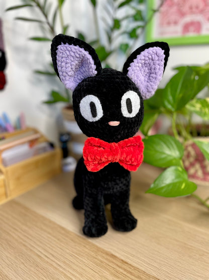 Grand chat noir avec nœud rouge