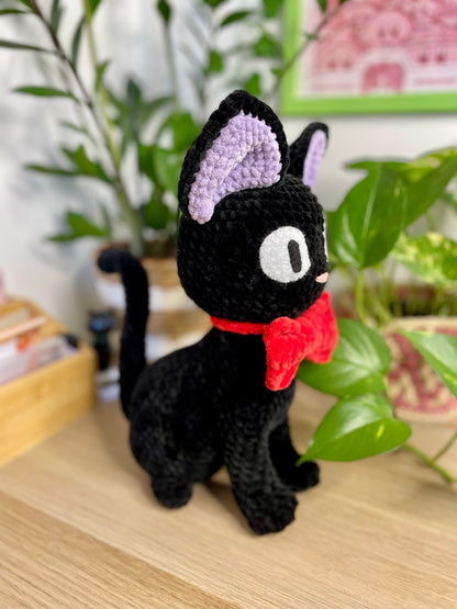 Grand chat noir avec nœud rouge