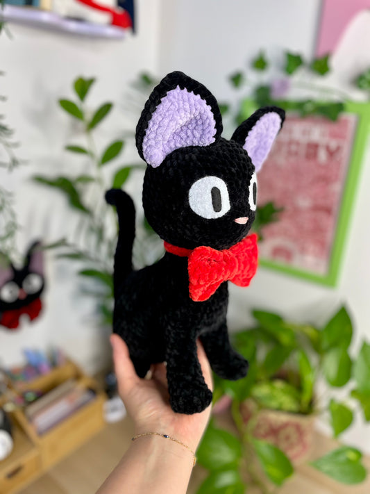 Grand chat noir avec nœud rouge