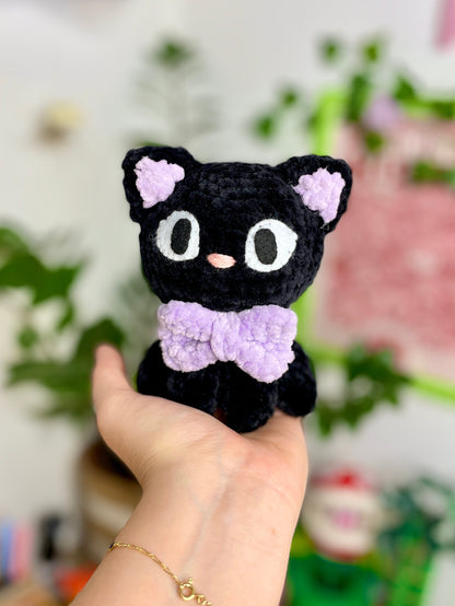 Petit chat noir avec nœud violet