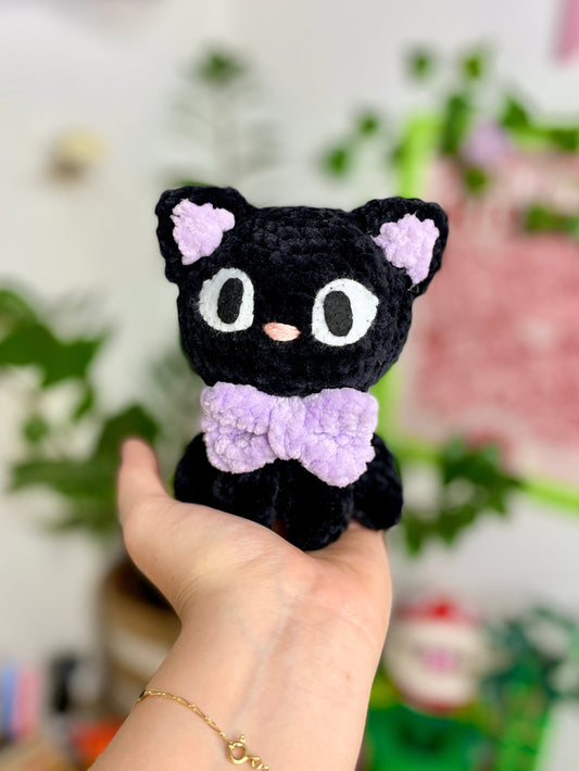 Petit chat noir avec nœud violet