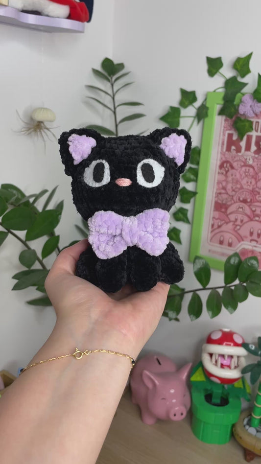 Petit chat noir avec nœud violet